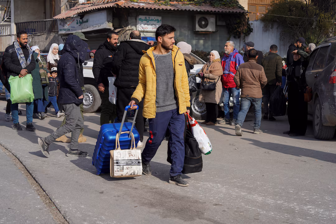 Un grupo de civiles lleva bolsas y pertenencias mientras huyen tras nuevos enfrentamientos entre el ejército sirio y las Fuerzas Democráticas Sirias (FDS), en Alepo, Siria, el 7 de enero de 2026. REUTERS/Karam al-Masri