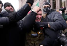 La respuesta popular frena la provocación ultraderechista de Jake Lang y señala a ICE como aparato central de represión, racismo institucional y violencia de Estado en EE. UU. Jake Lang, en el centro, se lleva las manos a la cabeza mientras abandona una concentración cerca del Ayuntamiento de Minneapolis el 17 de enero de 2026, Minnesota, EE. UU. | Yuki Iwamura / AP Photo