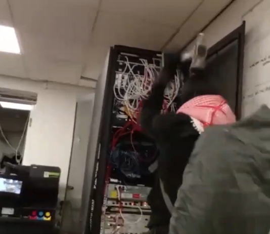 Activistas pro‑Palestinos sabotean fábrica aeroespacial en East Lothian en señal de protesta contra el complejo militar‑industrial Imagen de uno de los activistas martilleando un equipo electrónico | Captura de video