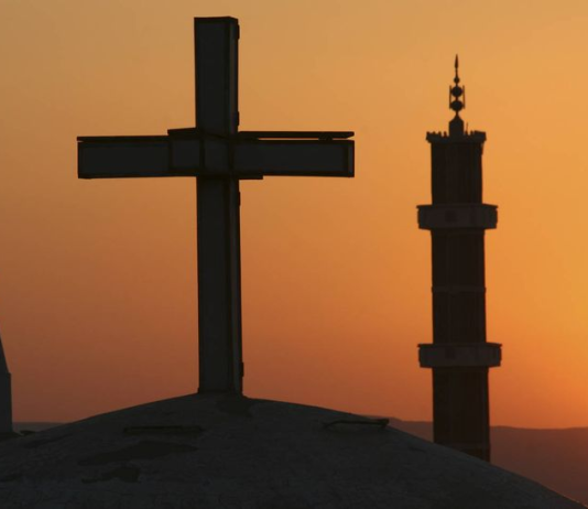 Encuentro Interreligioso de Murcia: veinte años tejiendo convivencia Fotografía de una mezquita situada junto a una iglesia | Istock