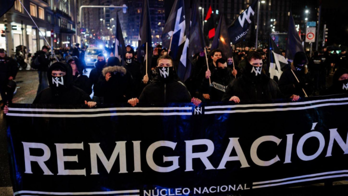 Militantes de Núcleo Nacional junto a una pancarta con el lema "remigración" durante una manifestación celebrada el 7 de febrero en Madrid | Mateo Lanzuela / Europa Press