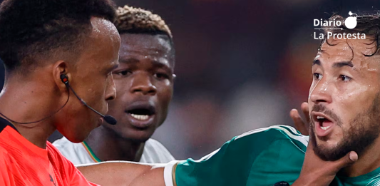 El árbitro de Somalia Omar Abdulkadir Artan pone la mano en el jugador de Argelia Youcef Belaili en la Copa Africana de Naciones 2024. Se le ha negado la entrada a Estados Unidos para el Mundial 2026. (KENZO TRIBOUILLARD/AFP)