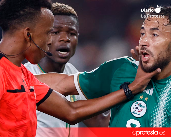 El árbitro de Somalia Omar Abdulkadir Artan pone la mano en el jugador de Argelia Youcef Belaili en la Copa Africana de Naciones 2024. Se le ha negado la entrada a Estados Unidos para el Mundial 2026. (KENZO TRIBOUILLARD/AFP) El árbitro de Somalia Omar Abdulkadir Artan pone la mano en el jugador de Argelia Youcef Belaili en la Copa Africana de Naciones 2024. Se le ha negado la entrada a Estados Unidos para el Mundial 2026. (KENZO TRIBOUILLARD/AFP)