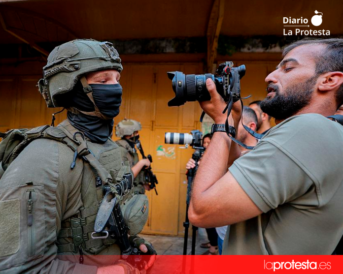 Imagen de archivo de periodistas frente a soldados en una calle estrecha de Hebrón | AFP/Mosab Shawer
