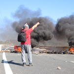 Un trabajador del metal ante una barricada de neumáticos ardiendo durante la primera jornada de huelga indefinida en el Valle de Escombreras, en Cartagena. | Foto: Dominic David Skerrett.